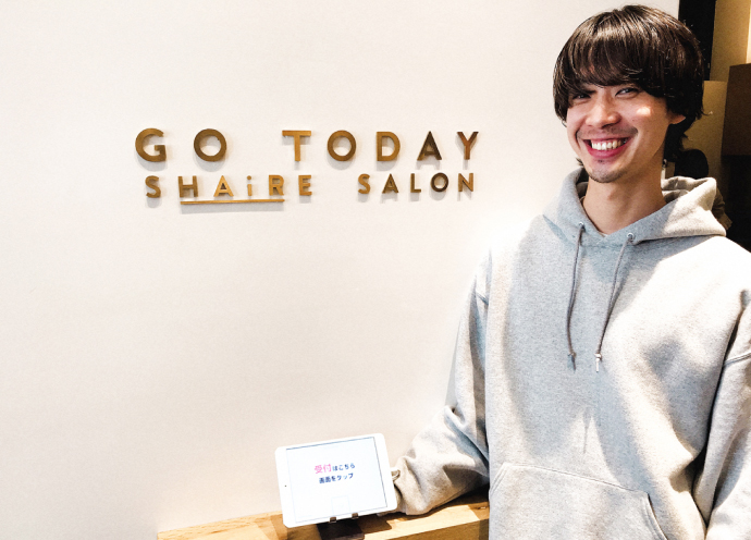 レセプショニストを手にするGO TODAY SHAiRE SALON」（GTSS）のオオイケモトキさん