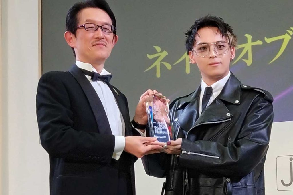 金子正信JNA副理事長㊧よりノベルコアさん㊨にトロフィー授与