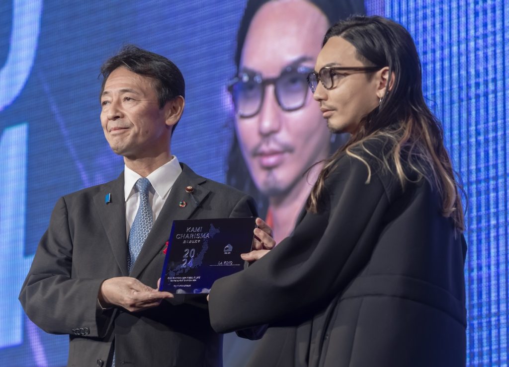 カミカリスマ(KAMICHARISMA)で一冠(カラー)を達成したLA KING代表のK ING氏と盾を授与する工藤彰三氏