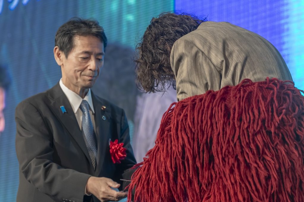 カミカリスマ（KAMICHARISMA）でヘアカラー2つ色を受賞した酒井元樹氏と盾を授与する工藤彰三氏