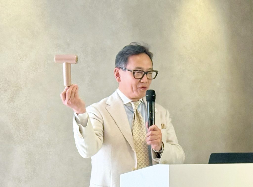 胸ポケットからツヤモイスト ドライヤー LIGHTを取り出した岡野社長