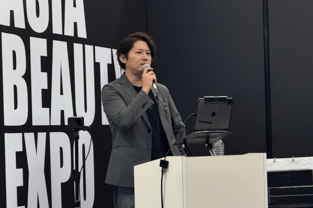 KINUJO(キヌージョ)がアジアビューティエキスポで、2日間に渡ってセミナーを開催した。2日目は、KINUJOの商品プロデュースを手掛けるiii(スリー)の寺村氏、COAのゆうだい氏らが、VRを活用した最新の美容教育を紹介した